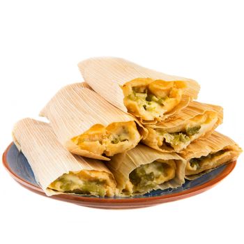 Cheese and chili tamales on plate and isolated on white background, view from eye level.