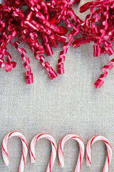 Candy canes and red curly ribbons with copy space in center.