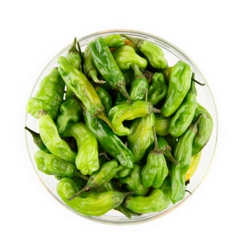 Bowl of japanese shishito peppers in a glass bowl, isolated and viewed from above.