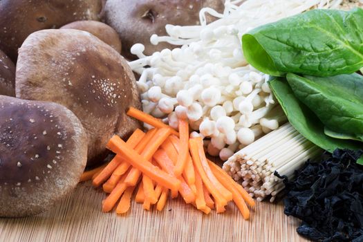 Ingredients for Udon: shiitake mushrooms,  enoki mushrooms, carrots, udon noodles, wakame, and spinach