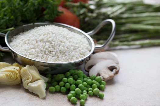 Rice, artichokes, peas, mushrooms and other ingredients for vegetarian paella