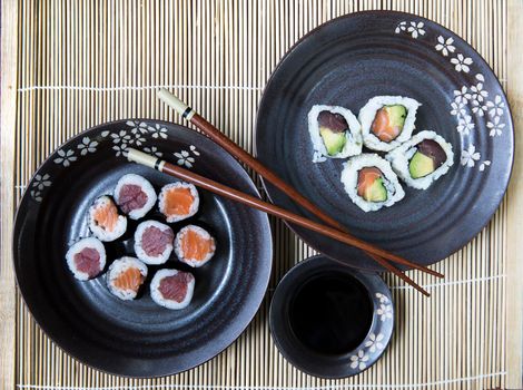 Tuna and salmon maki rolls with soy sauce and chop sticks.