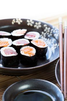 Tuna and salmon maki rolls with soy sauce and chop sticks.