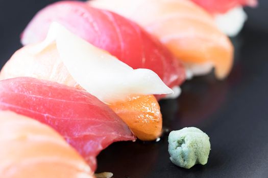 Salmon and tuna nigiri rolls with ginger and wasabi.