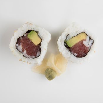 Fresh tuna and avocado uramaki sushi rolls with wasabi and ginger.