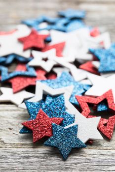 Pile of red white and blue patriotic star decorations on wooden table