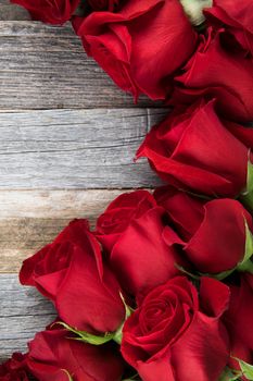 Romantic red roses for a special occasions on a wooden background with copy space.