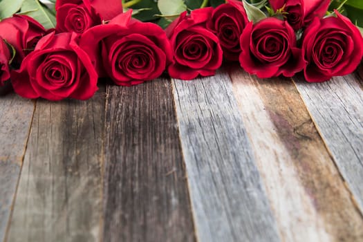 Romantic red roses for a special occasions on a wooden background with copy space.