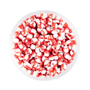 Small container of glass seed beads isolated on white background overhead view.