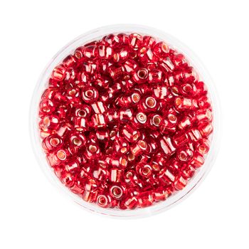 Small container of glass seed beads isolated on white background overhead view.