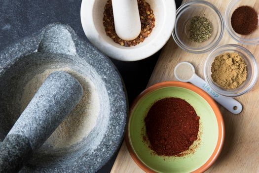 Mortar and pestle and small bowls with spices for taco seasoning.