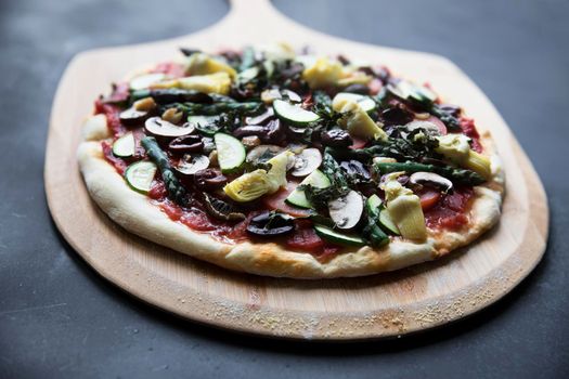 Homemade vegan pizza on pizza peel