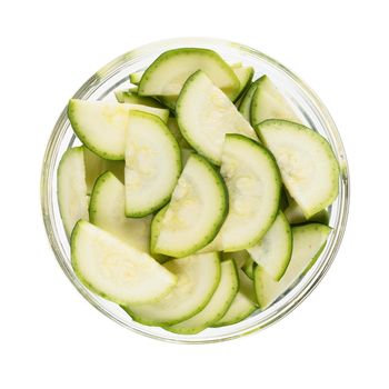 Half zucchini slices in glass bow and isolated on white background