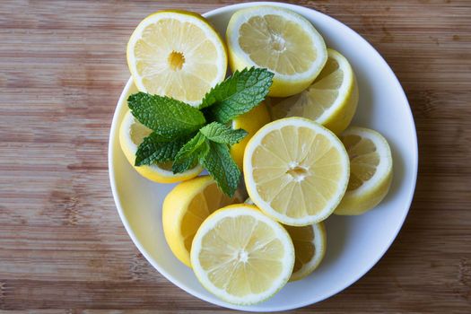 White bowl with lemon halves and fresh mint leaves