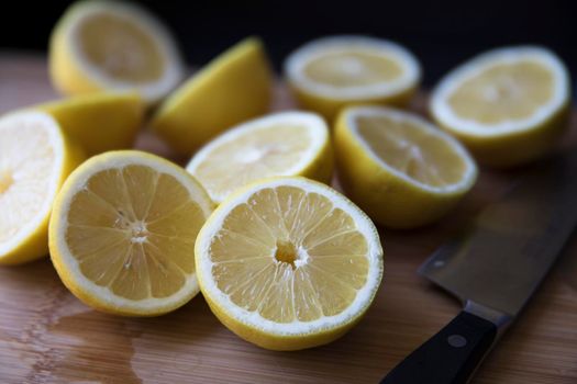 Lemon halves on cutting surface with chef's knife.