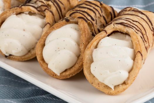 Close up of pastries Stuffed with sweet cream and drizzled with chocolate.