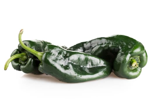 Three whole poblano peppers on white background with shadow.