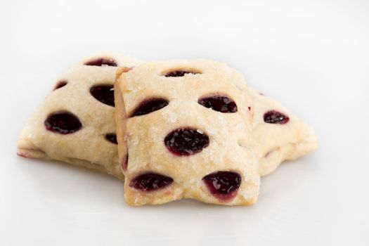 Three berry filled mini strudels on a white background