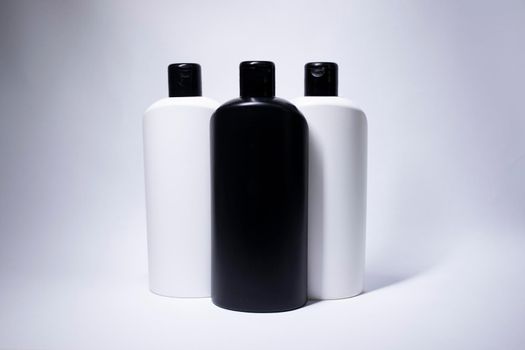 Composition of three white and black shampoo bottles with no label. body care and beauty concept. Copy space. . High quality photo