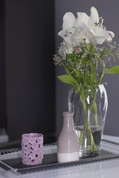 set of home decoration - candle, vase and flowers - on a handmade black metal tray at the kitchen. home interior and decor concept. High quality photo