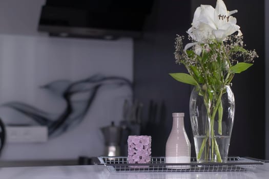 set of home decoration - candle, vase and flowers - on a handmade black metal tray at the kitchen. home interior and decor concept. High quality photo