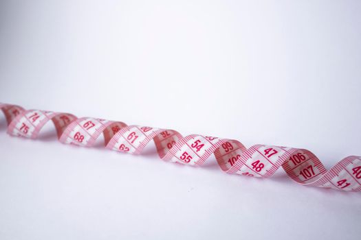 Red measuring tape on white background. Loss weight concept. Top view. Copy space. Isolated. . High quality photo