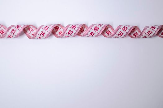 Red measuring tape on white background. Loss weight concept. Top view. Copy space. Isolated. . High quality photo