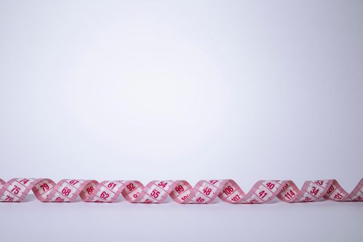 Red measuring tape on white background. Loss weight concept. Top view. Copy space. Isolated. . High quality photo