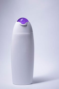 white shampoo bottle with purple neck and no label. body care and beauty concept. Copy space. High quality photo