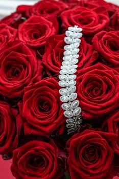 Gemstone jewellery, wedding fashion and luxe shopping concept - Luxury diamond bracelet and bouquet of red roses, jewelry love gift on Valentines Day and romantic holidays present