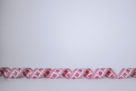 Red measuring tape on white background. Loss weight concept. Top view. Copy space. Isolated. . High quality photo