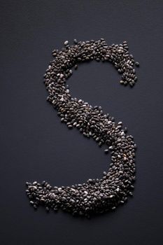 Letter 'S' written with chia seeds on gray background, top view, copy space.