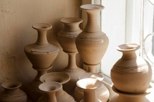 clay vases of various sizes standing near the window