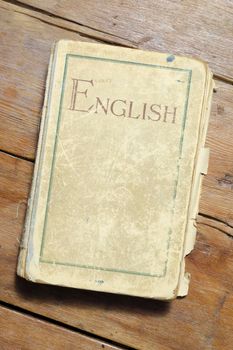 very old English textbook on vintage wooden table