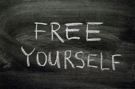 free yourself phrase handwritten on school blackboard