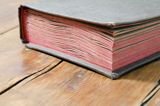 fragment of old book laying on the weathered wooden surface
