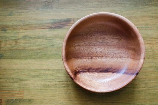 empty wooden bowl on green wooden table