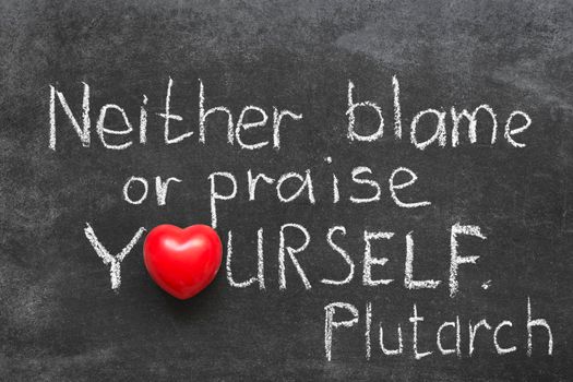 famous Ancient Greek philosopher Plutarch quote about praise or blame yourself handwritten on blackboard
