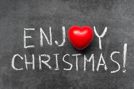 enjoy Christmas exclamation handwritten on chalkboard with heart symbol instead of O
