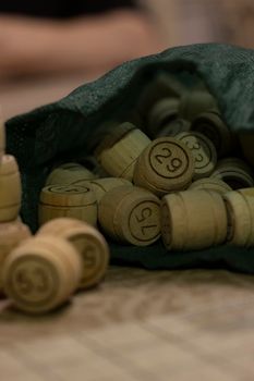 Lotto or bingo game. Wooden kegs with cards for playing bingo or lotto. Spending time during quarantine. Old game with wooden elements. The concept of leisure at home in isolation with the family.