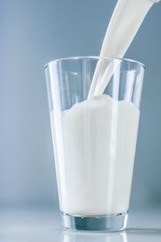 Dairy, healthy nutrition and breakfast concept - World Milk Day, pouring into glass on marble table