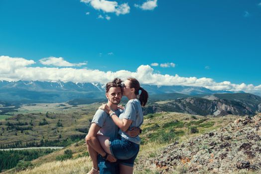 Loving couple together on Altai mountain looking at a view