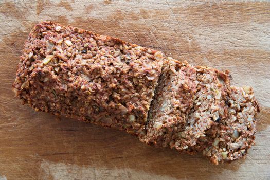 Vegan lentil loaf and slices on cutting board.