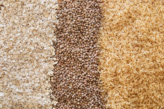 Three healthy products: brown rice, lentils, and oats as a food background.
