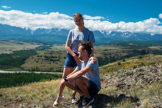 Loving couple together on Altai mountain looking at a view