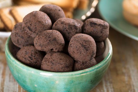 Close up of chocolate truffles in green bowl.