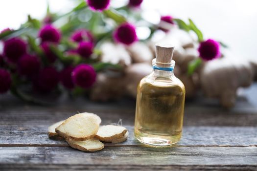 Bottle of ginger oil with ginger slices.