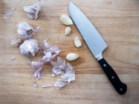 Garlic cloves and bulbs on cutting board with knife