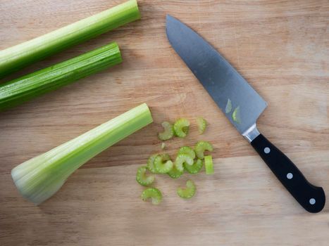 Celery stalks and slices with knife on cutting board