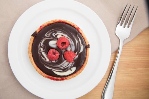 White and dark chocolate tartlet with raspberries.